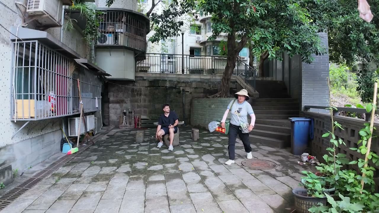 An open corridor inside the Baixiangju housing block with laundry and residents.